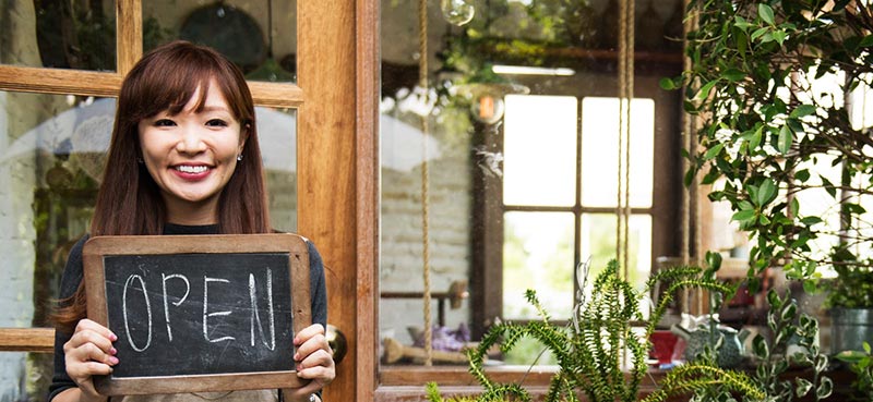 Lady holding we're open sign