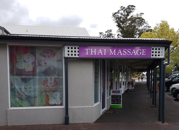 On the street outside looking at Sawaddee Thai Massage building and sign