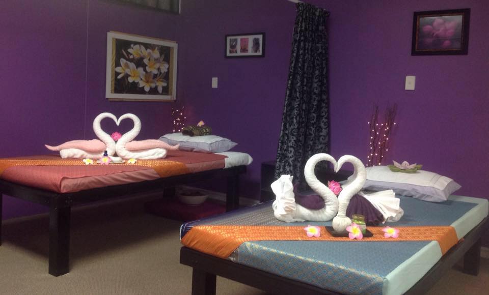 Two massage tables inside Sawaddee decorated with towels shaped into swans forming a heart with their beaks