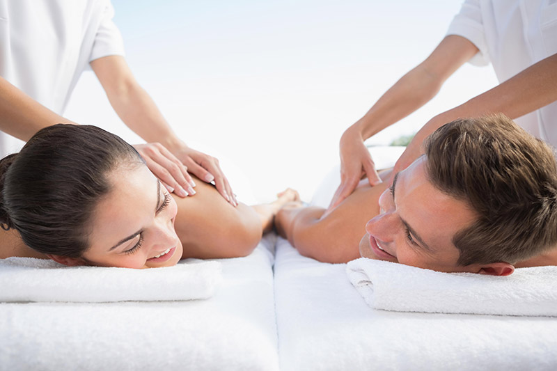 A couple enjoying a shared couples massage experience together